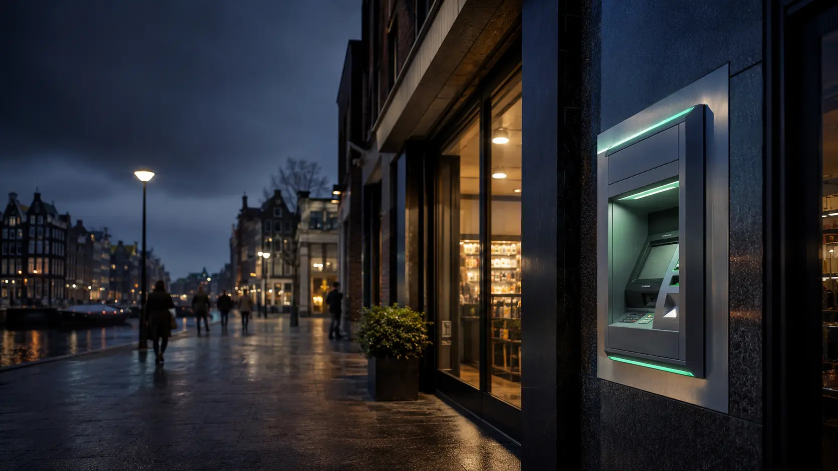 Moderne geldautomaat aan een Nederlandse winkelstraat in de avond